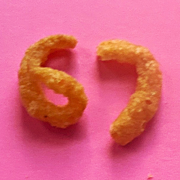 Funyuns Puffed Snack 67-Shaped Cheese Puff Pieces (2) on Pink Plate