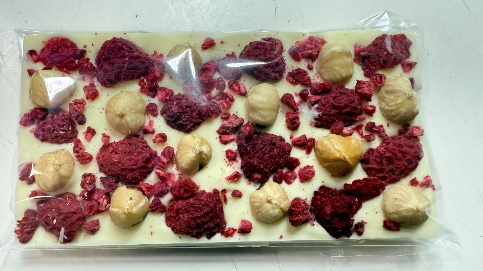White Chocolate Bar Sweet & Sour taste Raspberry & Hazelnut on top 100g .